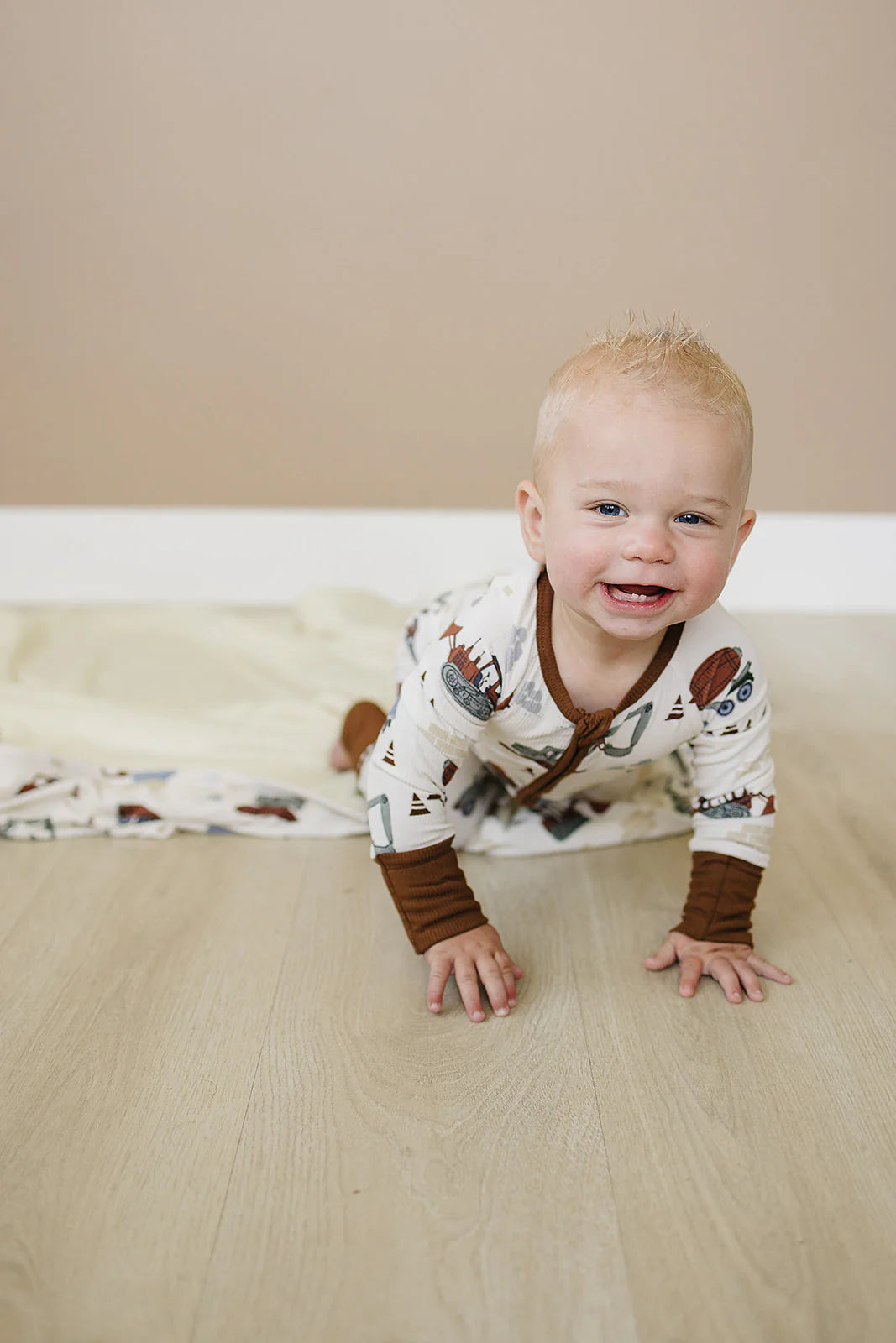 Baby onesie with construction vehicle pattern on a white background. Mebie Baby