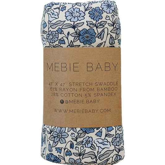 Floral swaddle blanket with brown label featuring 'Mebie Baby' branding.