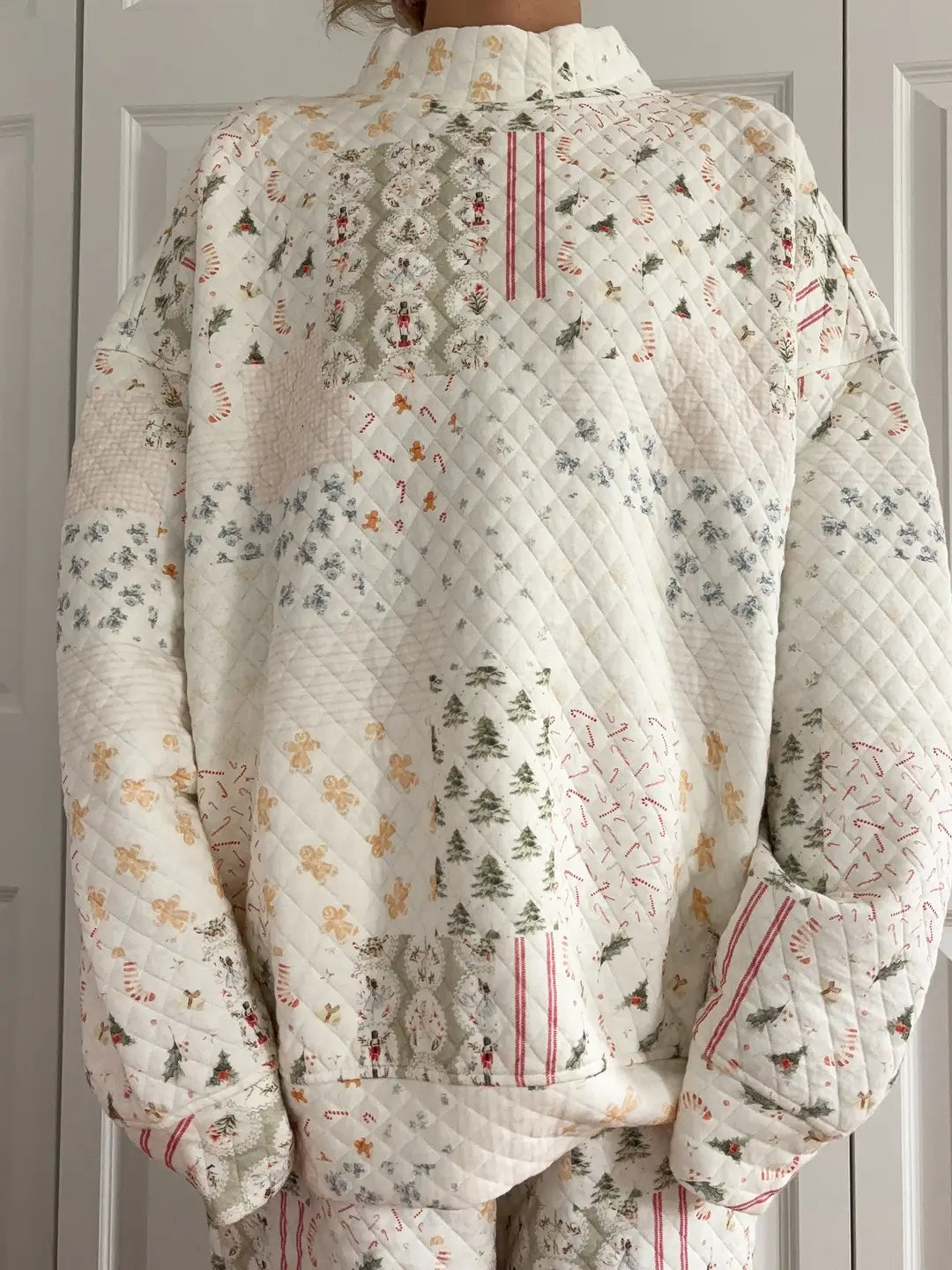 Quilted jacket with a Christmas-themed pattern against a neutral background