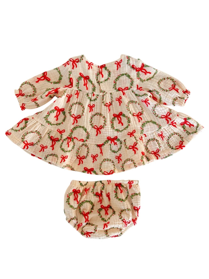 Children's dress with red bows and green wreaths on a white background